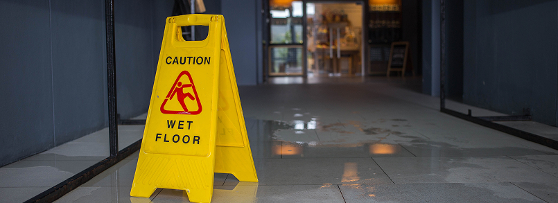 wet floor caution sign in dim hallway